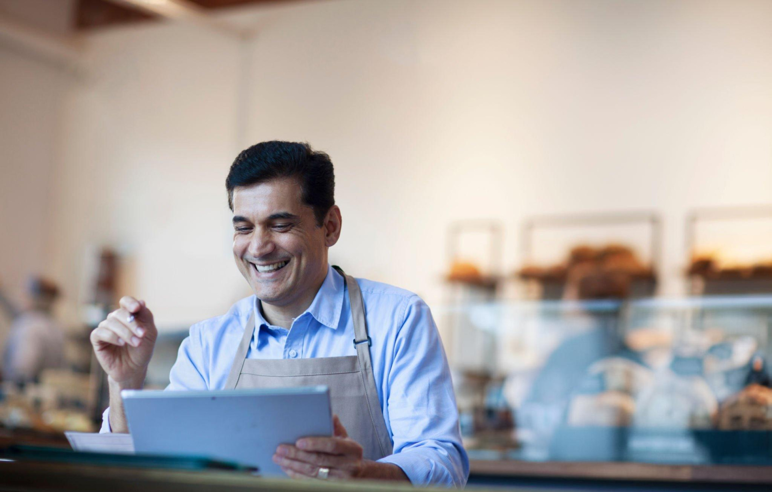 a man smiling in front of his tablet